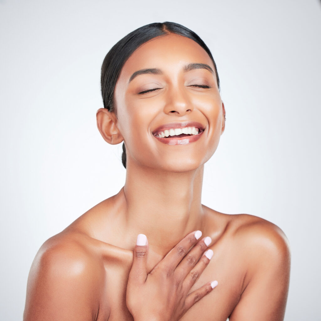 Woman with clear glowing skin representing the results of healing gut health and addressing acne from the inside out